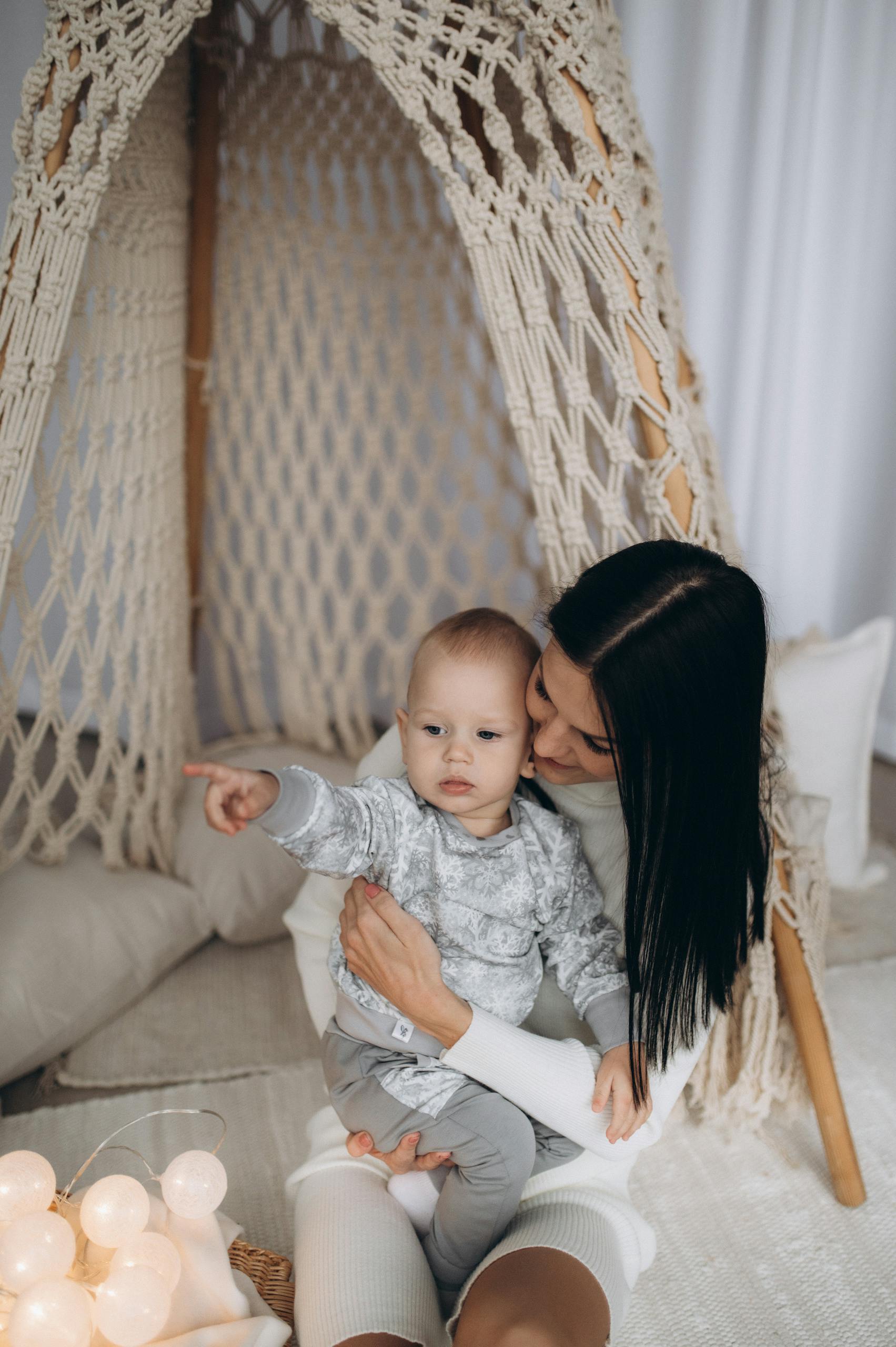 A tender moment between mother and baby inside a cozy home tent.